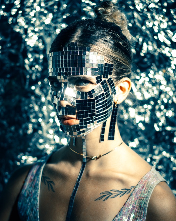 MIRROR PORTRAIT &mdash; A disco-mosaic mask portrait shot against glitter bokeh.
